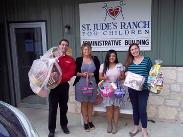 Four people with Easter baskets and donations